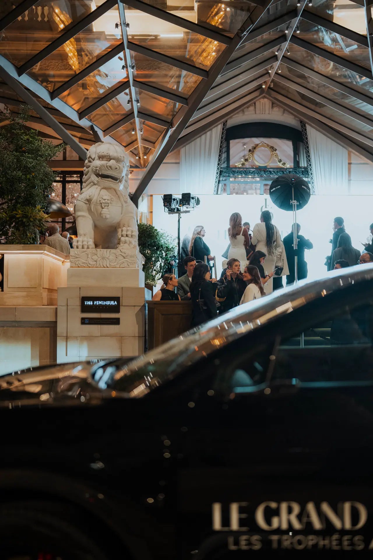 Voiture garée devant le Peninsula au premier plan, vue sur le photocall au loin, à l'entrée du Peninsula