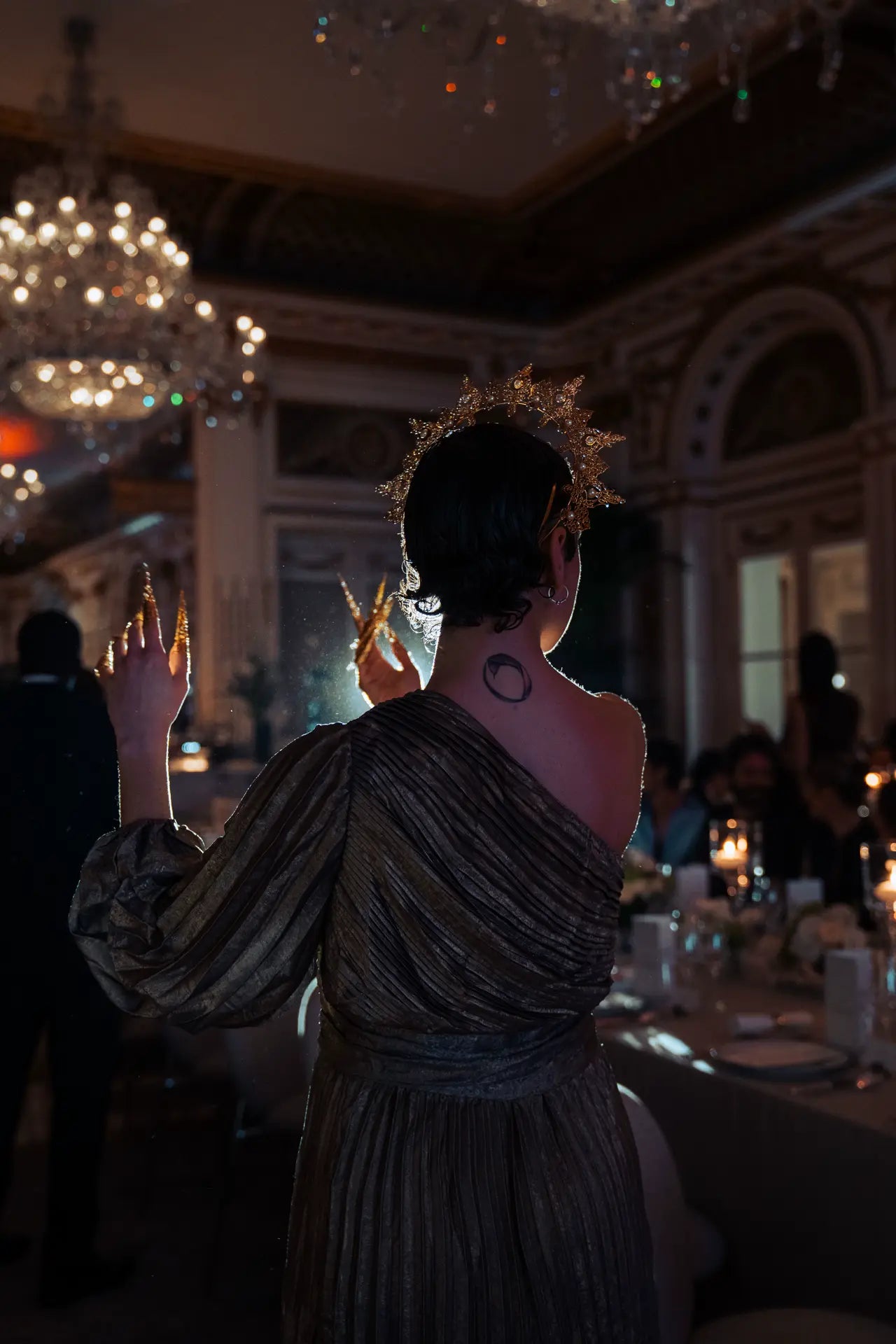 Danseuse en performance. De dos vers les invités, elle porte une couronne