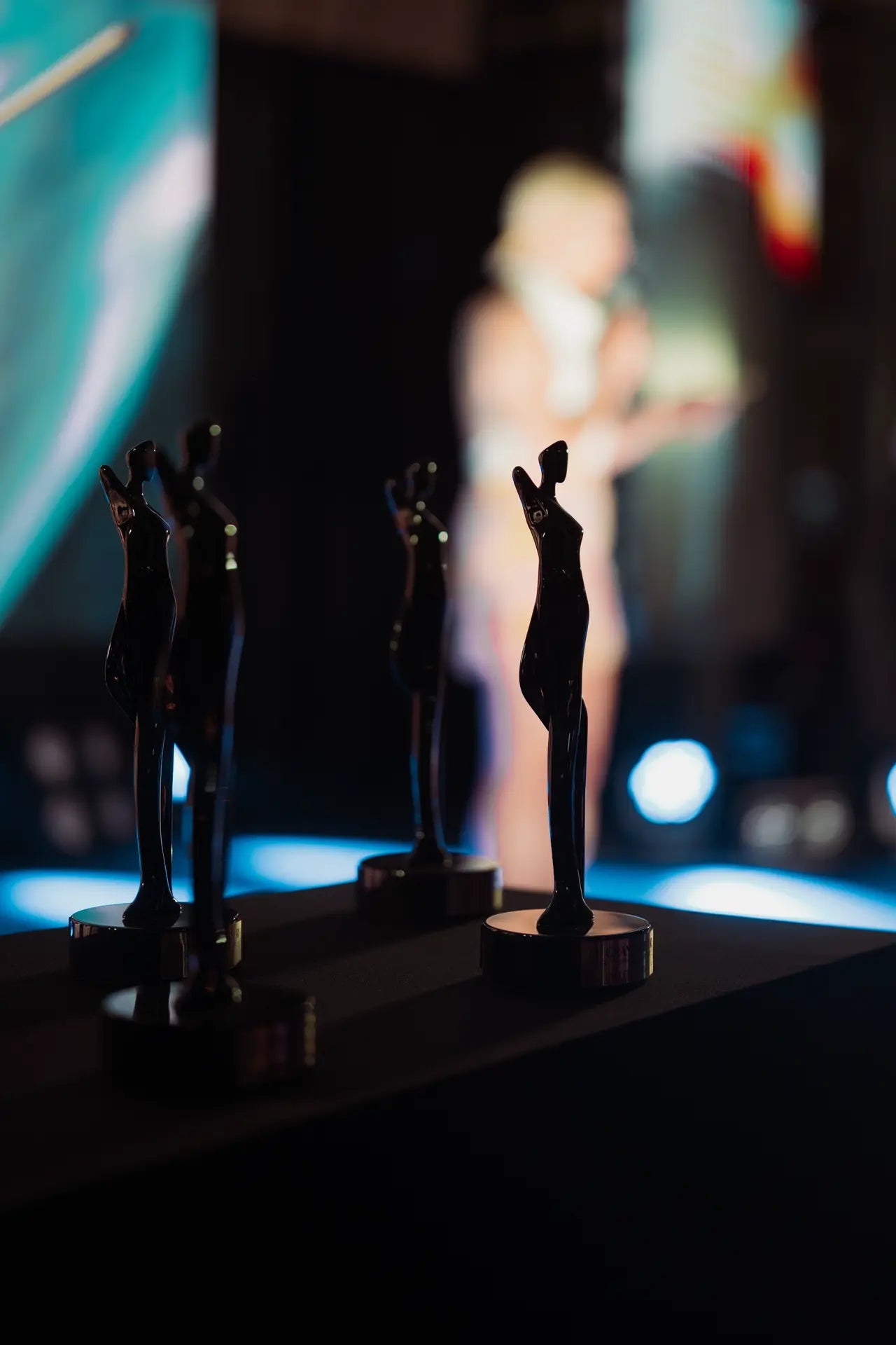 Trophées posé devant la scène des Trophées Madame, fond flou sur la scène
