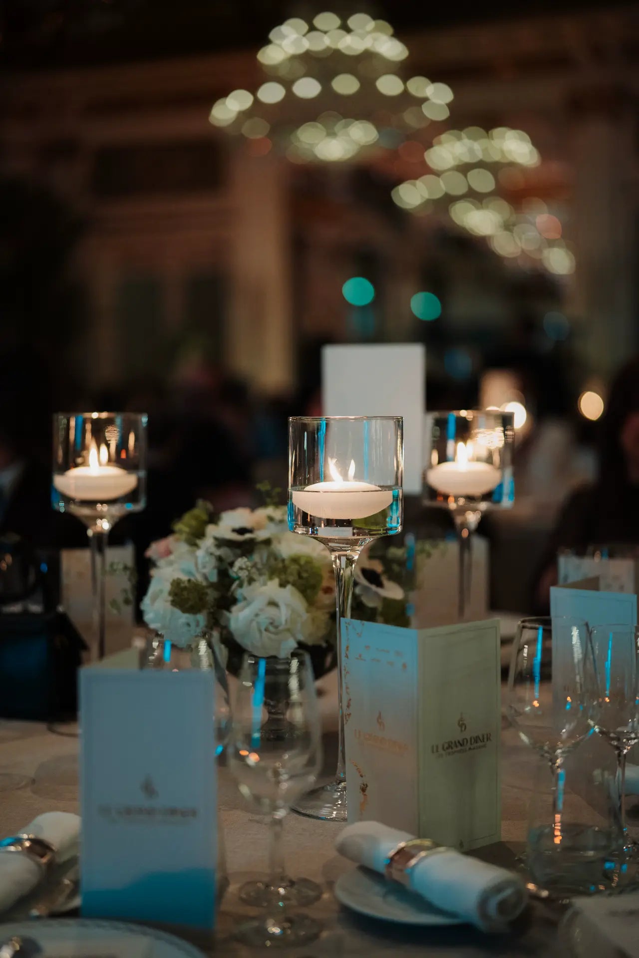 Vue sur la table des Trophées Madame pendant la cérémonie. Table dressée avec bougeoirs suspendus et menus posés