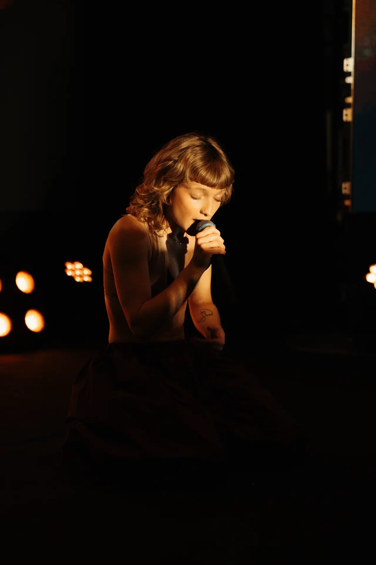 Zélie en performance, peu de luminosité, lumière braquée sur elle, clair obscur, waw trop belle.