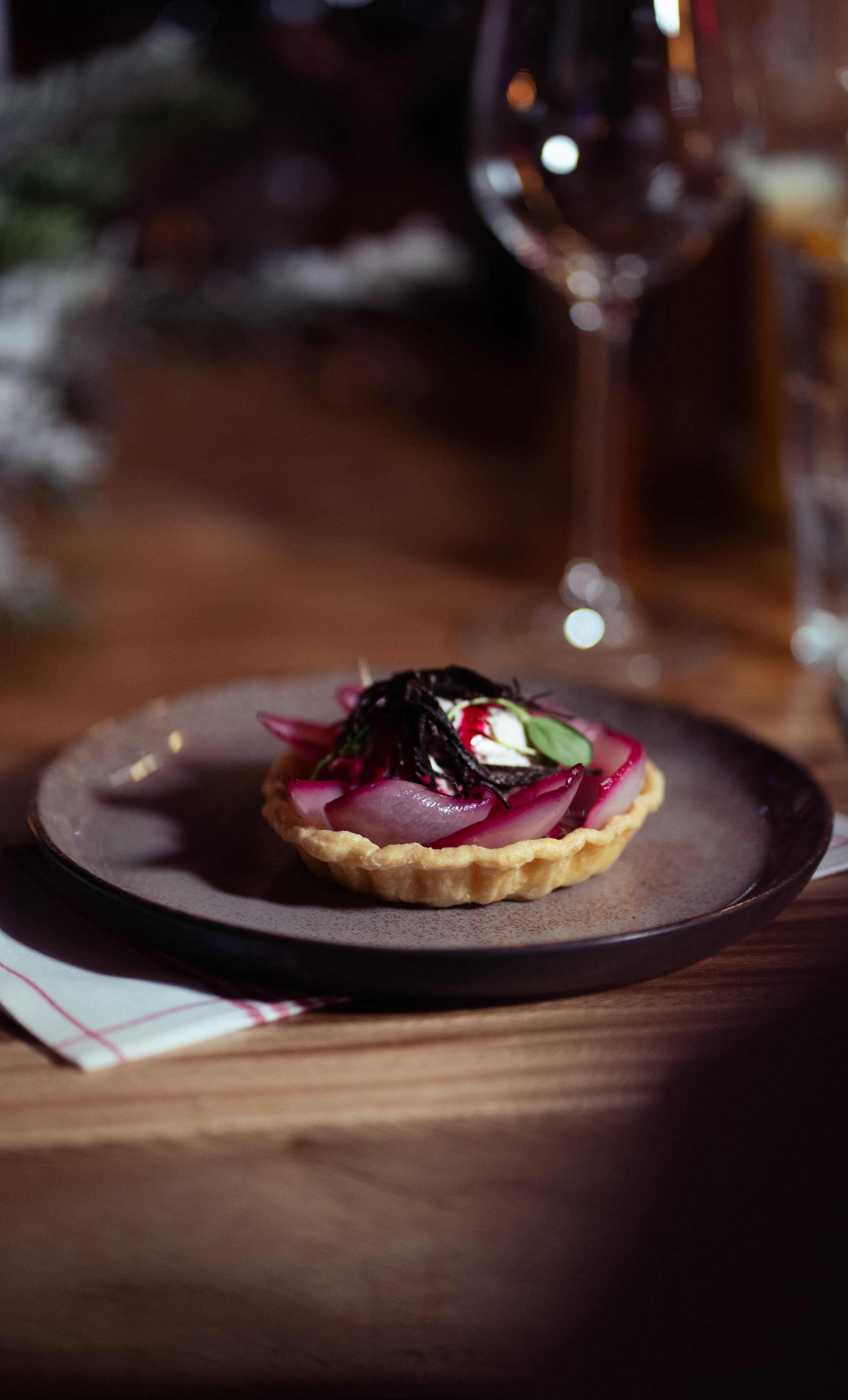 Vue d'un plat - Tarte tatin d'échalottes à la truffe, crème légère au moût de raisin, jus végétal et toona cress